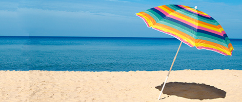 a beach shore with an umbrella