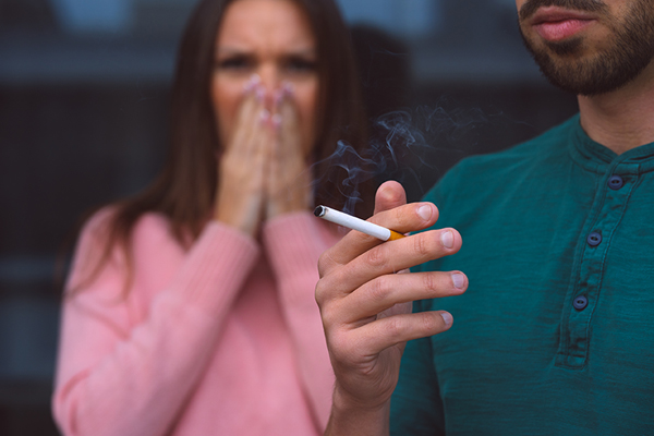 a man smoking infront of a woman
