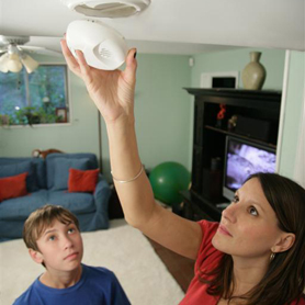 Graphic showing a man demonstrating a Smoke Alarm for two senior citizens