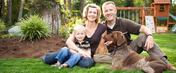 Graphic of a man, woman child and dog sitting on a lawn