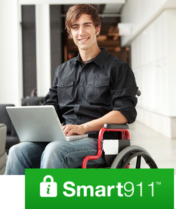 a man in a wheelchair using a laptop with the Smart911 logo