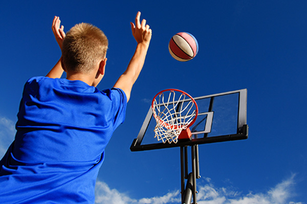 a child shooting a basketball into a hoop