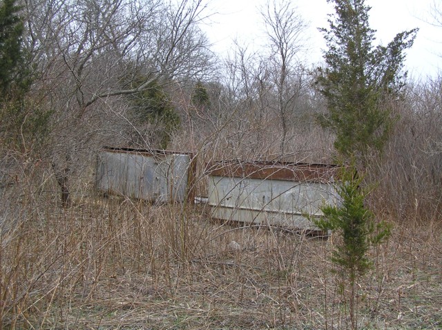 image 36b - 2 large metal bins in a field clearing