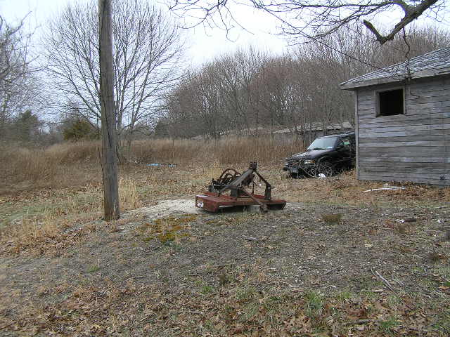 image 47b - old machinery and an abandoned truck sit next to an old abandoned house