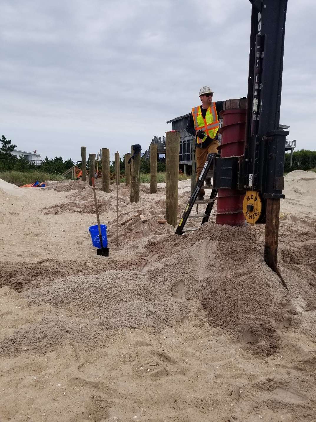 worker adding poles to sand at the davis park shore